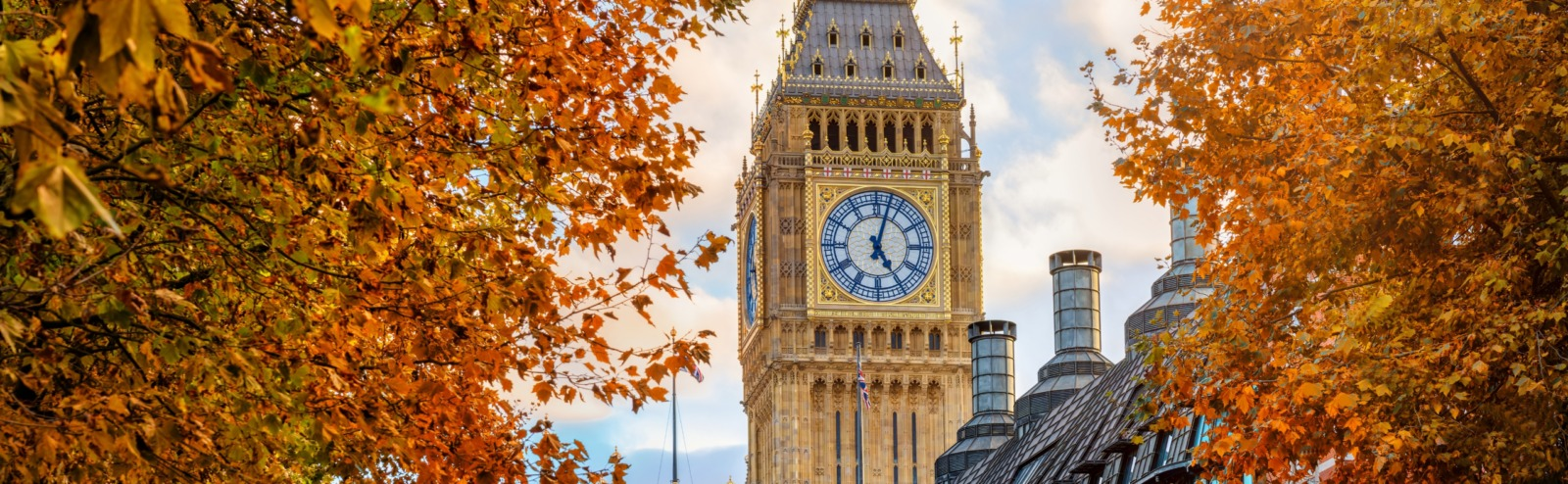 Elizabeth Tower and the Houses of Parliament framed by autumn leaves in London