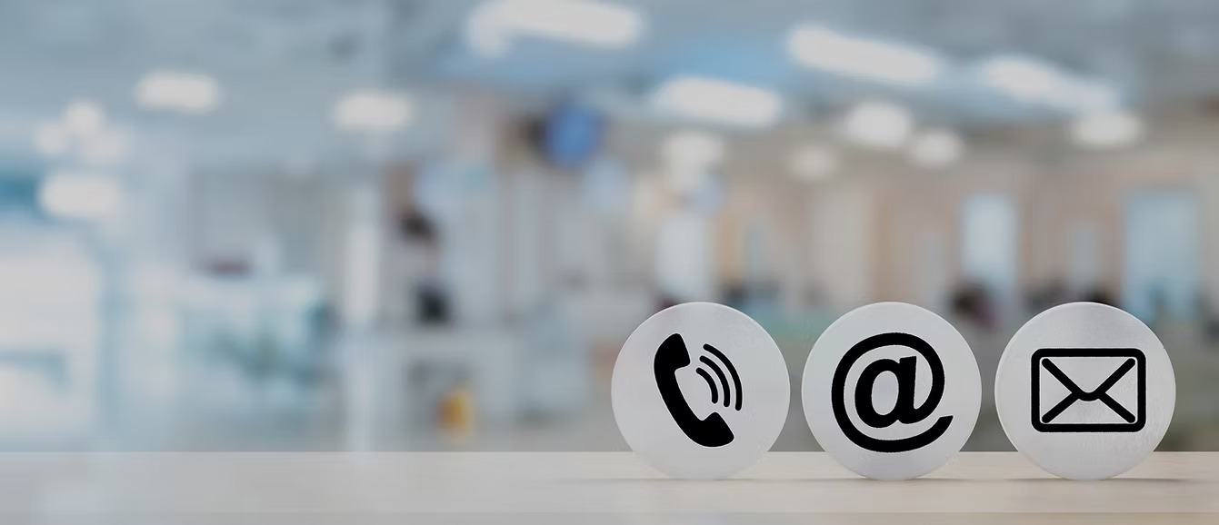 Telephone and email contact symbols in a bright office setting